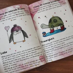 Aufgeklapptes Tagebuch mit handgemalten Figuren zu den Gefühlen Liebe und Traurigkeit
